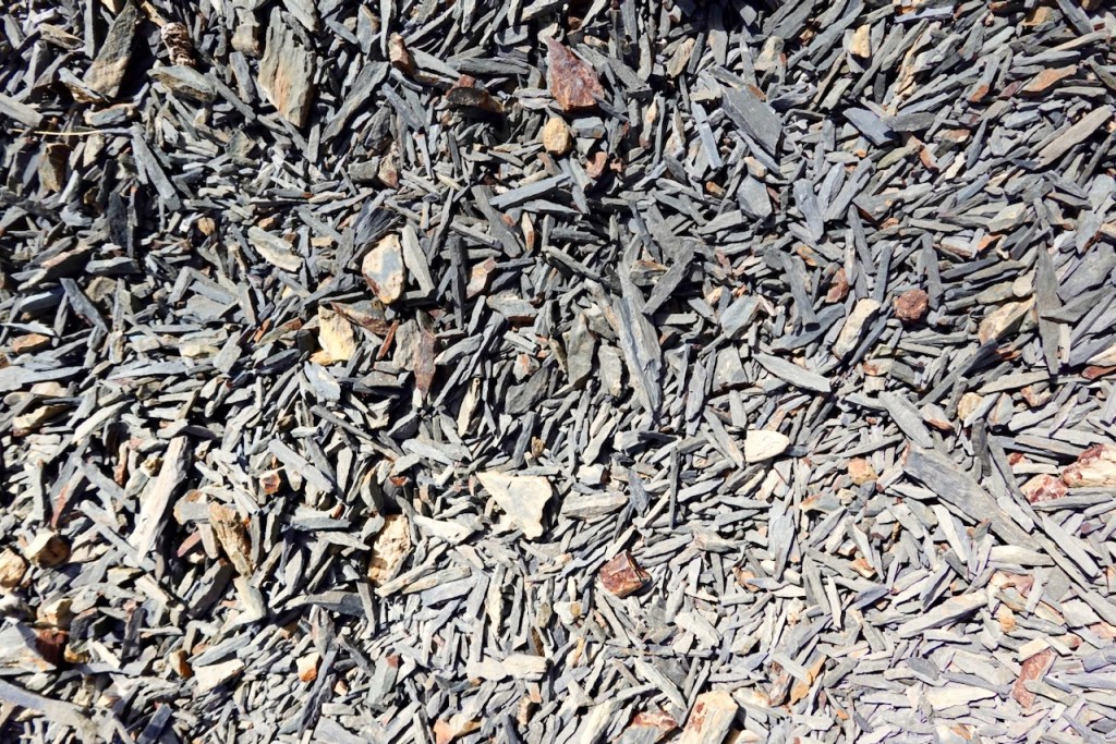 Close-up of a texture of gray slate stone pieces scattered on the ground.
